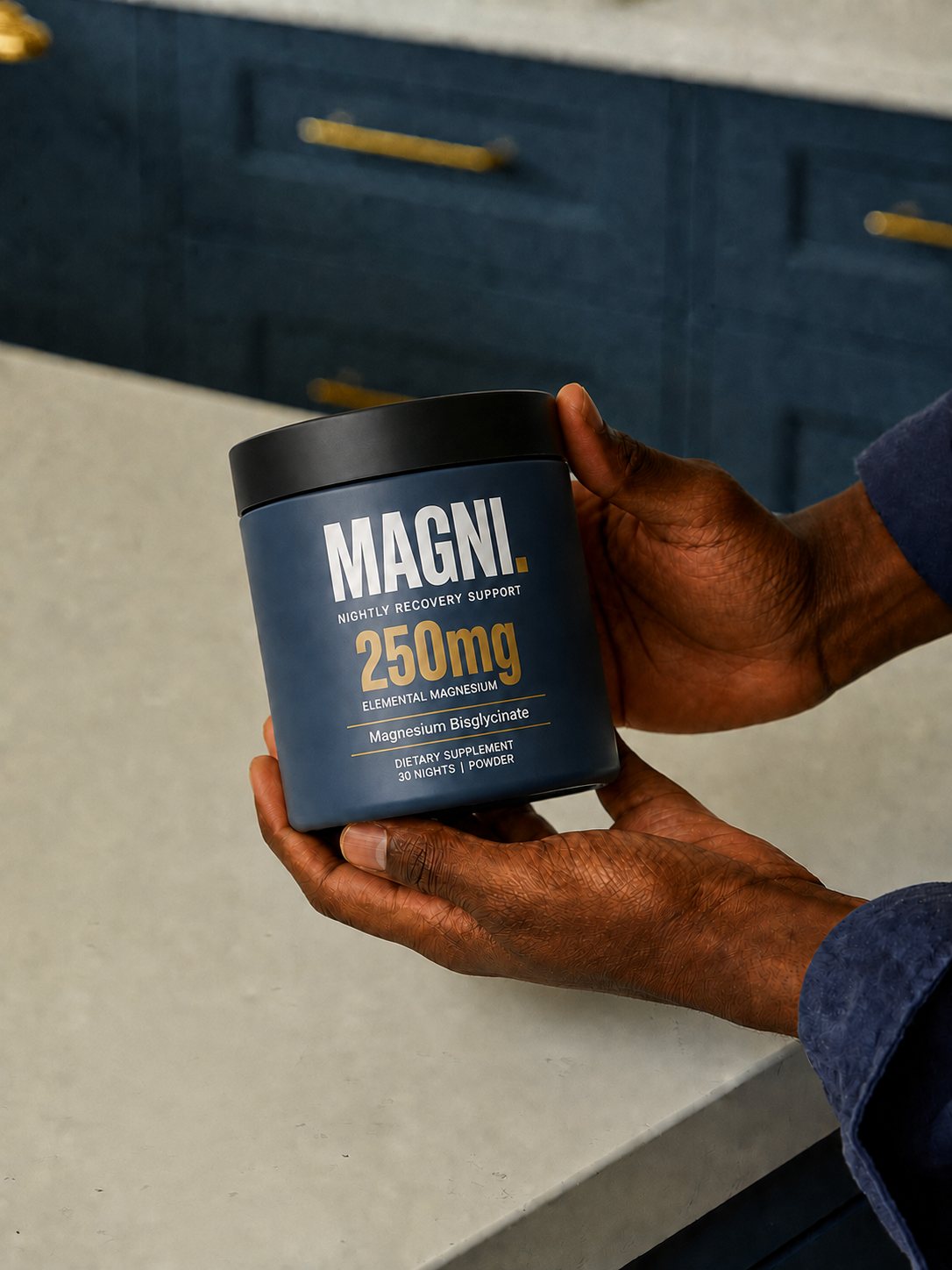 Hands holding the corrected slate-blue MAGNI tub with the elemental magnesium dose visible.